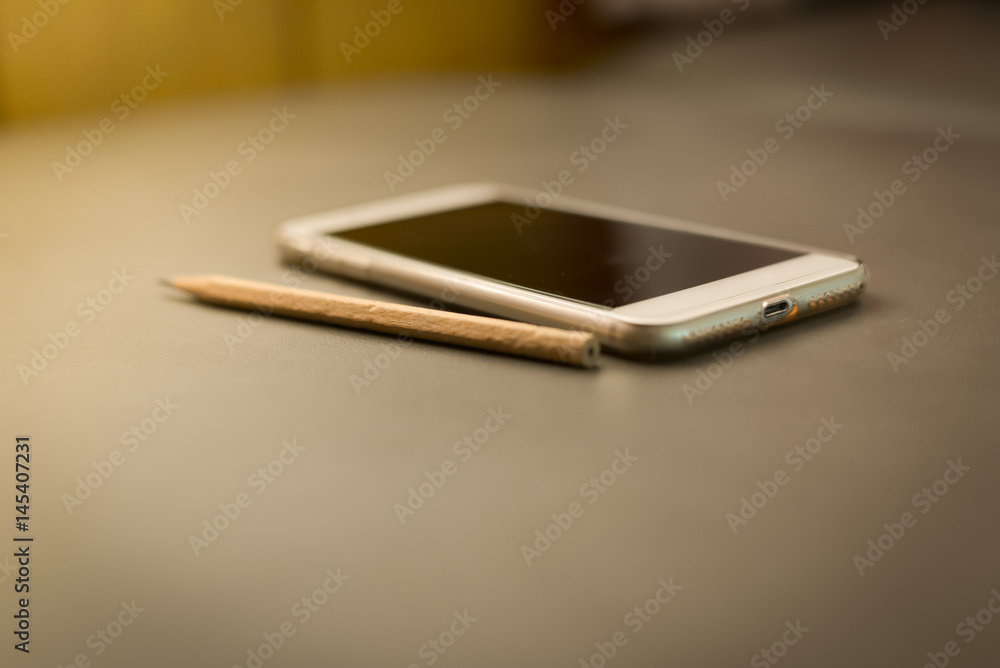 White smart phone on leather texture White smart phone on leather texture