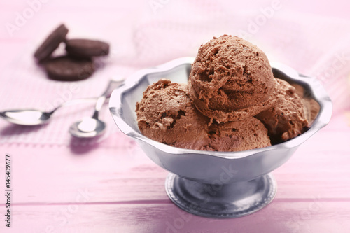 Metal bowl with delicious chocolate ice cream on pink wooden table