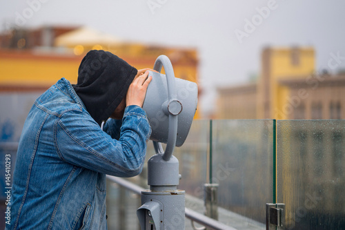 Obraz na plátně the man looks through his binoculars on the lookout