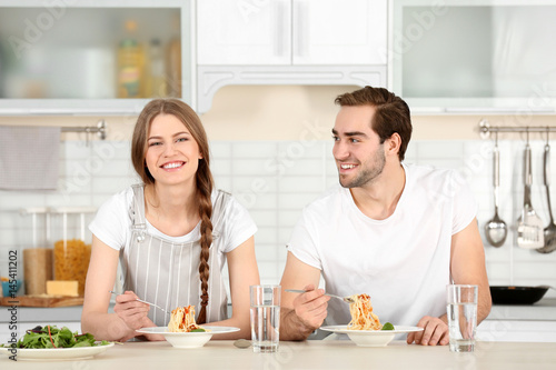 Young couple eating pasta o...