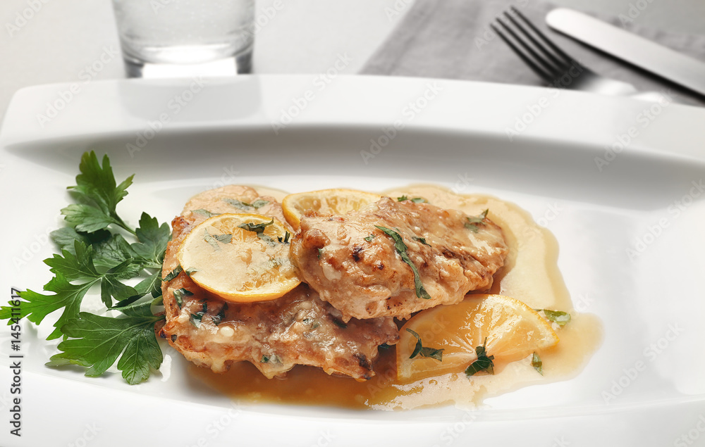 Tasty Italian chicken piccata with lemon on plate Tasty Italian chicken piccata with lemon on plate