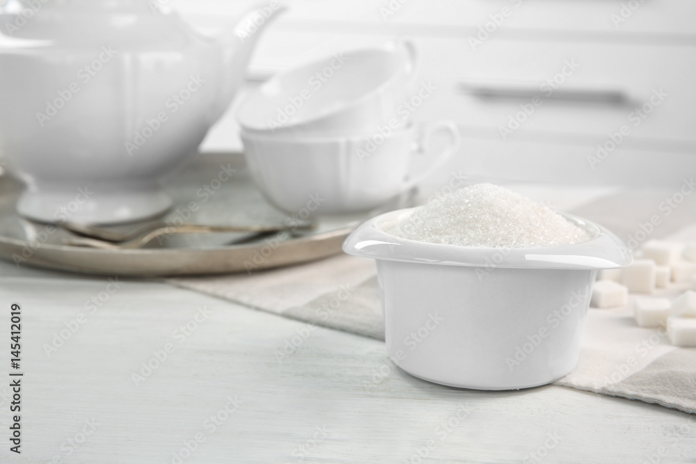 White bowl with sugar on kitchen table White bowl with sugar on kitchen table