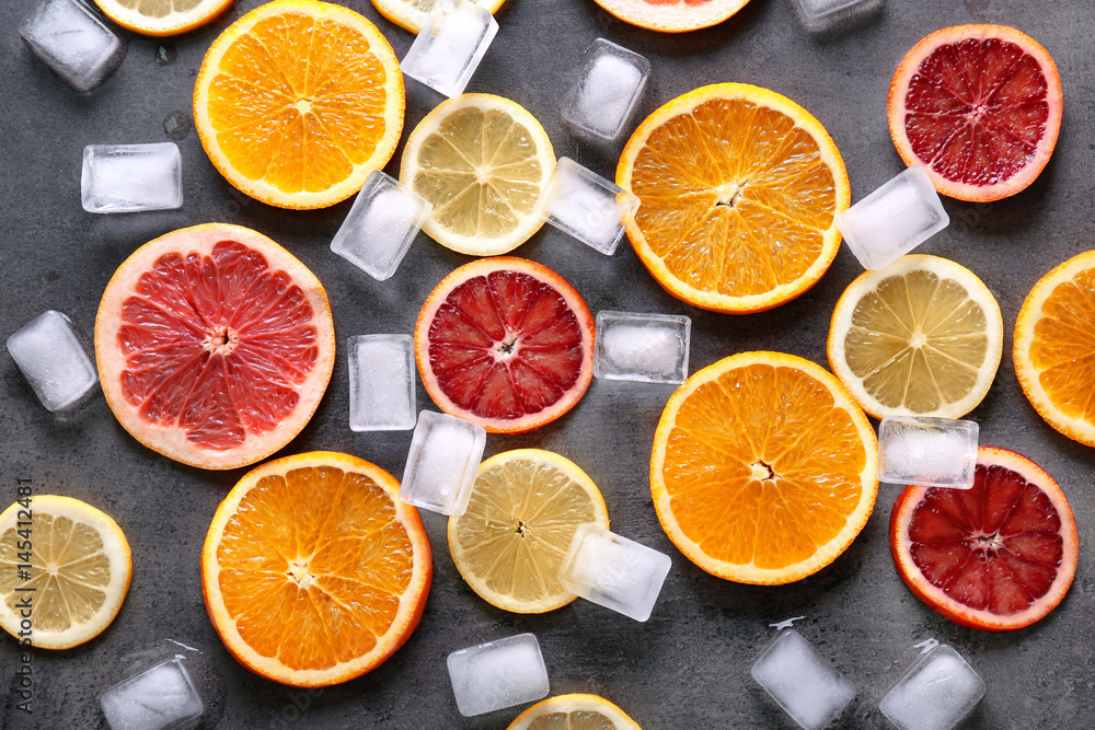 Juicy composition of citrus fruits and ice cubes on grunge background Juicy composition of citrus fruits and ice cubes on grunge background