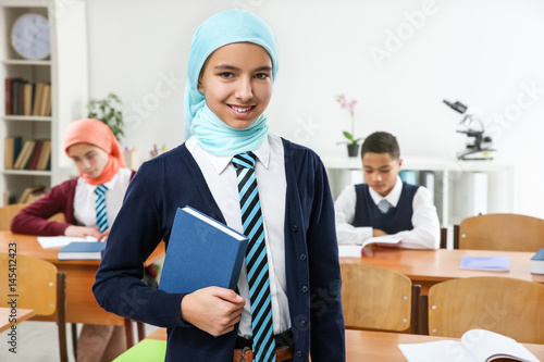 Cute girl with book standin...
