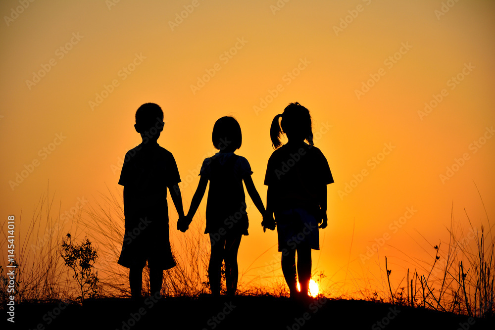 Silhouette  friendship of three on sunset mountain.