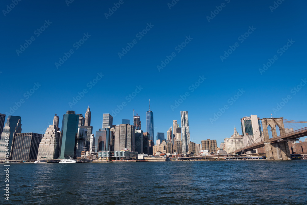 Obraz premium アメリカ・ニューヨークのスカイスクレイパーとブルックリン橋 青空バック