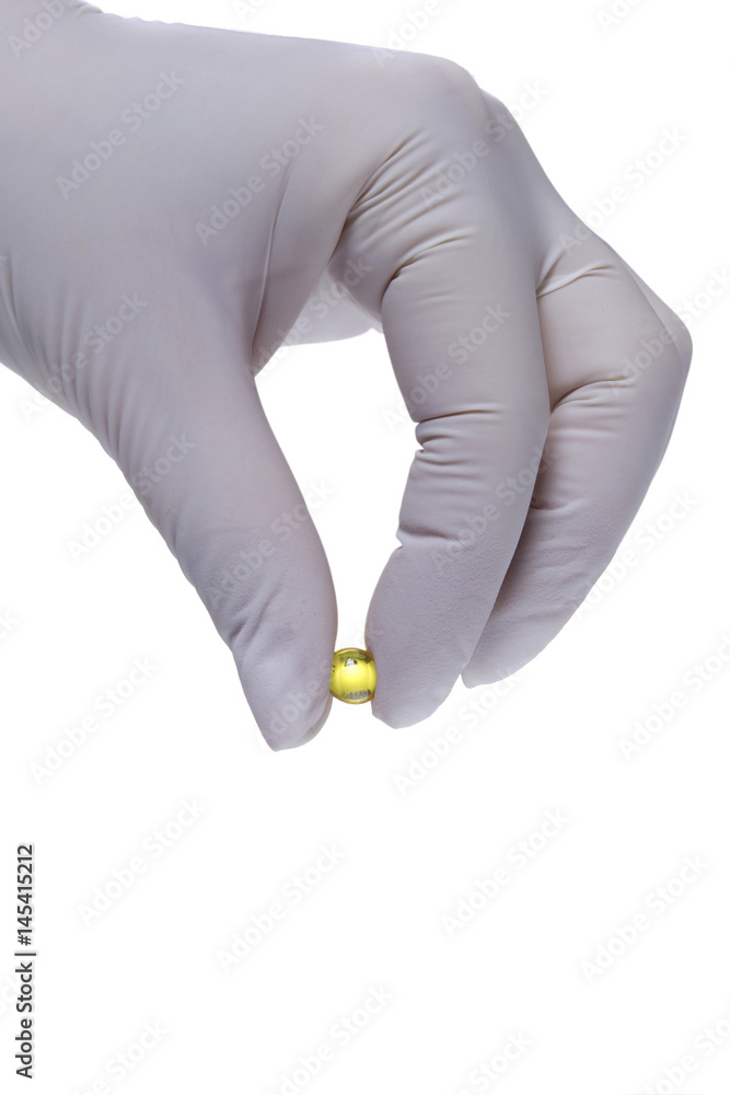 Fototapeta premium Hand in latex glove holding a pill