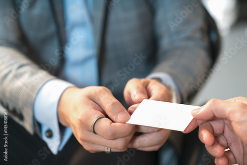 Closeup portrait of two successful business executive exchanging business card