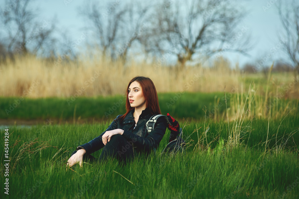 Beautiful redhead girl on a spring walk . Hiking