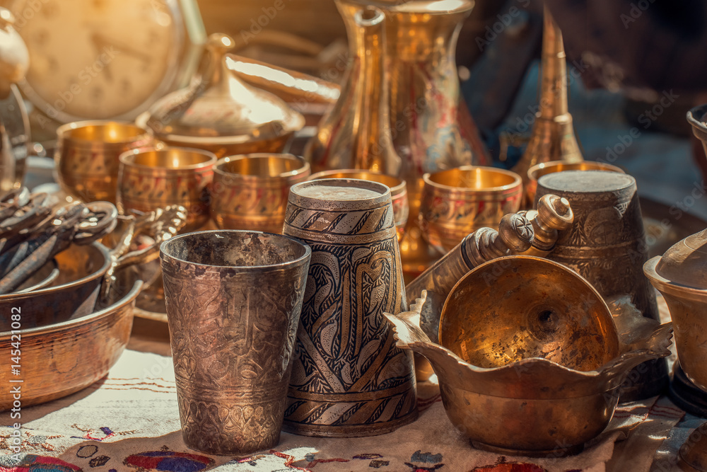old copper metal glasses and pitcher on counter in sunday flea market. Antique bazaar old copper metal glasses and pitcher on counter in sunday flea market. Antique bazaar