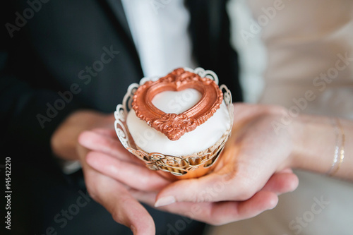 Couple holding wedding cupcake