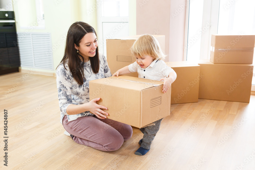 Happy young family with unpacking boxes at new home on moving day Happy young family with unpacking boxes at new home on moving day