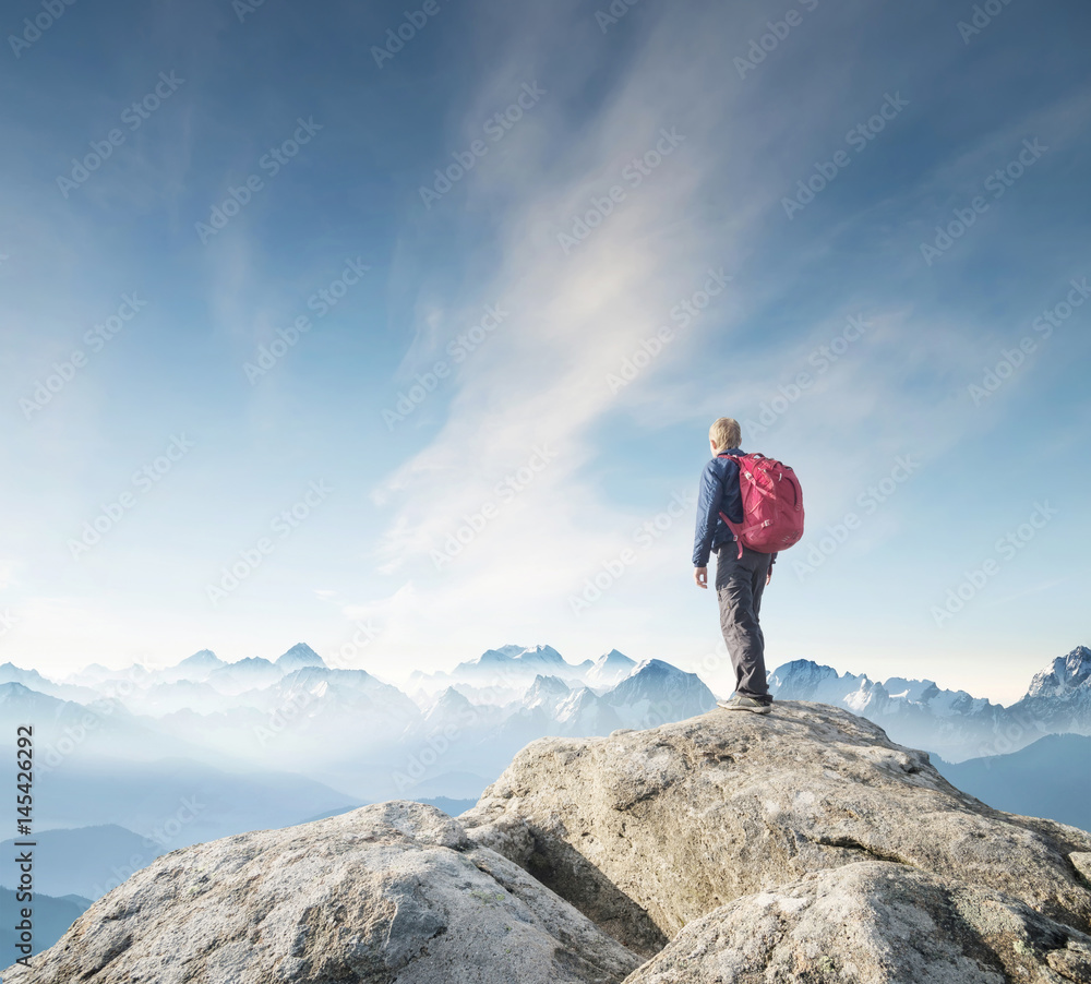 Obraz premium Tourist on the peak of high rocks. Sport and active life concept.