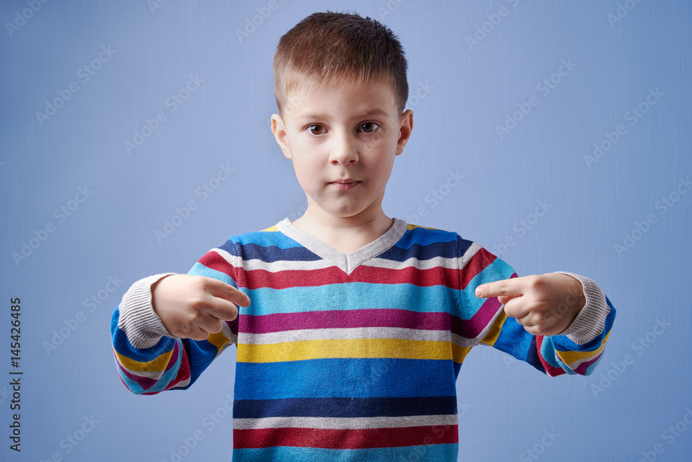 Cute European boy pointing to himself with fingers. He is on blue background. He is looking in the camera. Cute European boy pointing to himself with fingers. He is on blue background. He is looking in the camera.