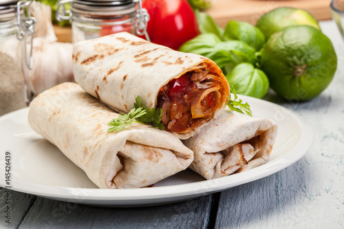 Mexican burritos wraps with mincemeat, beans and vegetables