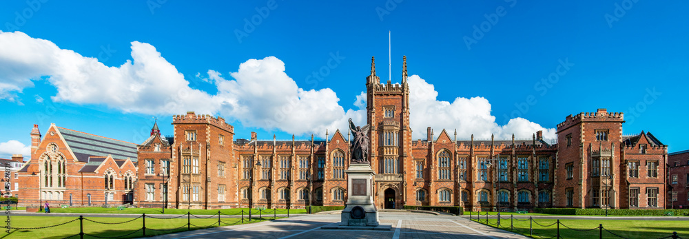 The Queen's University of Belfast with a grass lawn in sunset light. Wide panorama,