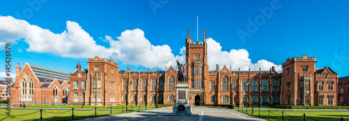 The Queen's University of Belfast with a grass lawn in sunset light. Wide panorama,