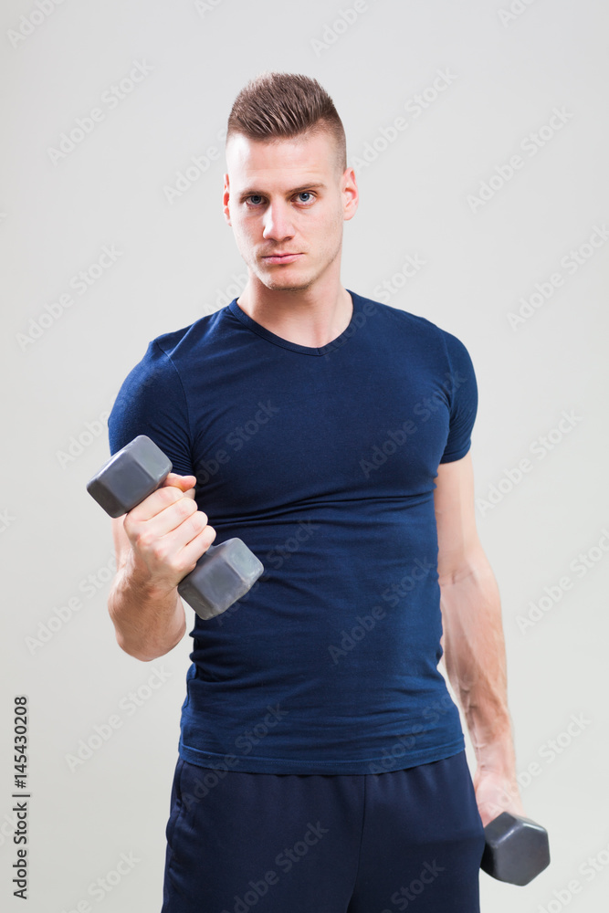 Studio shot image of young man who is exercising with weights. Studio shot image of young man who is exercising with weights.