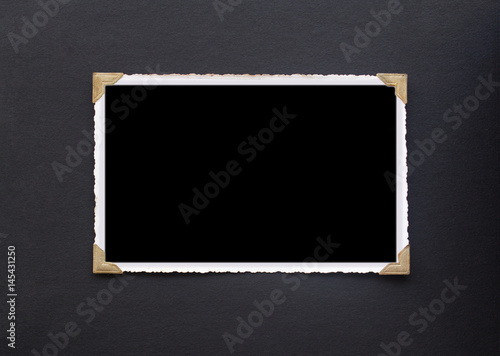 Photo frame - real old photo with black blank space for copy photo pasted with gold coloured photo holder corners onto black vintage album paper page - Photograph