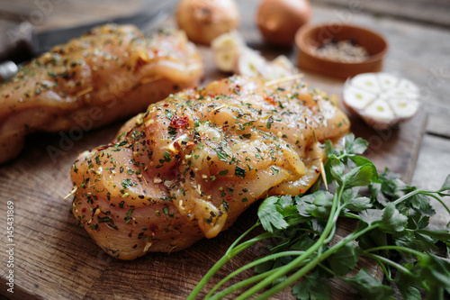Spicy chicken breast with parsley and garlic on wooden board