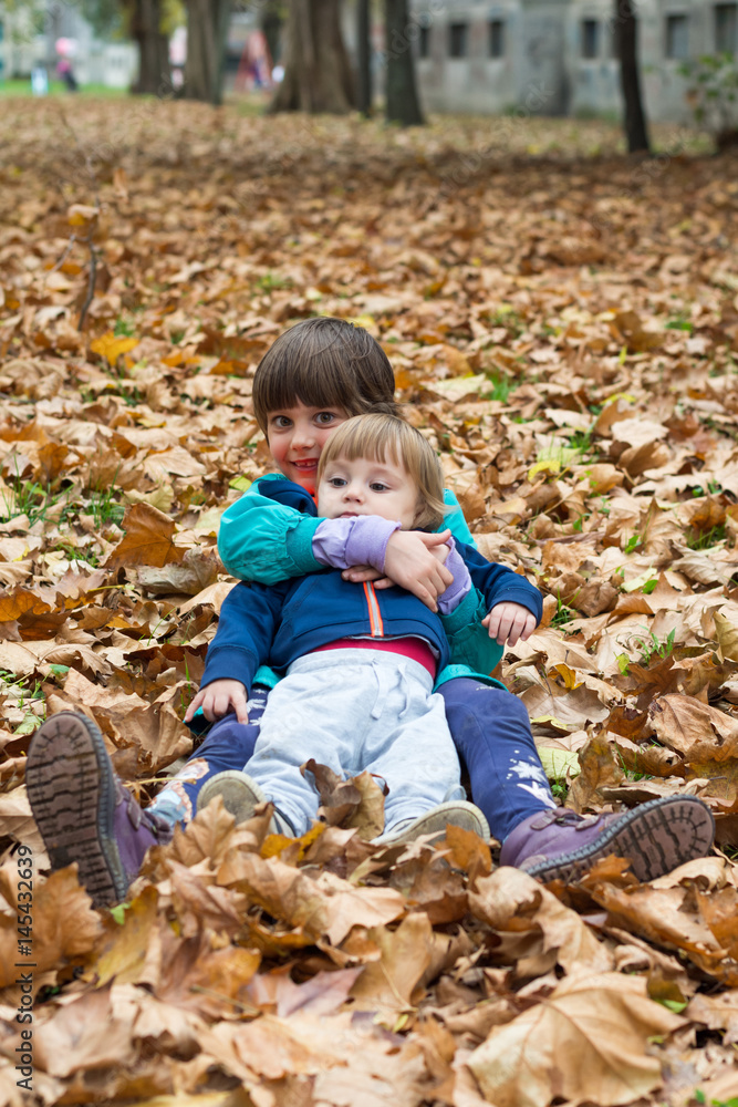 Brother and sister are laughing and playing in autumn Brother and sister are laughing and playing in autumn