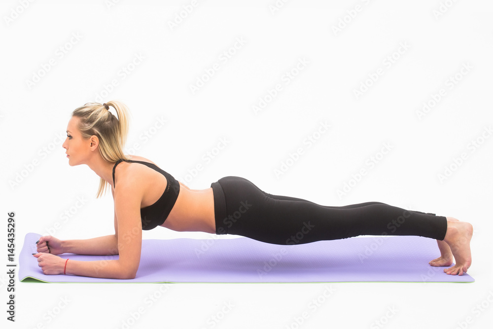 Pretty sporty girl athlete exercising on yoga mat