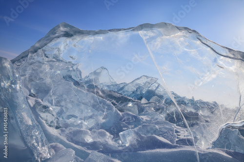Fotografie View on field of blue broken ice through the ice block on sky background
