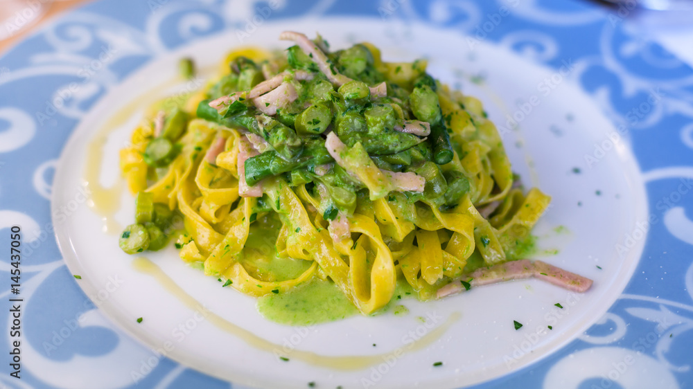 plate with tagliatelle, asparagus and ham