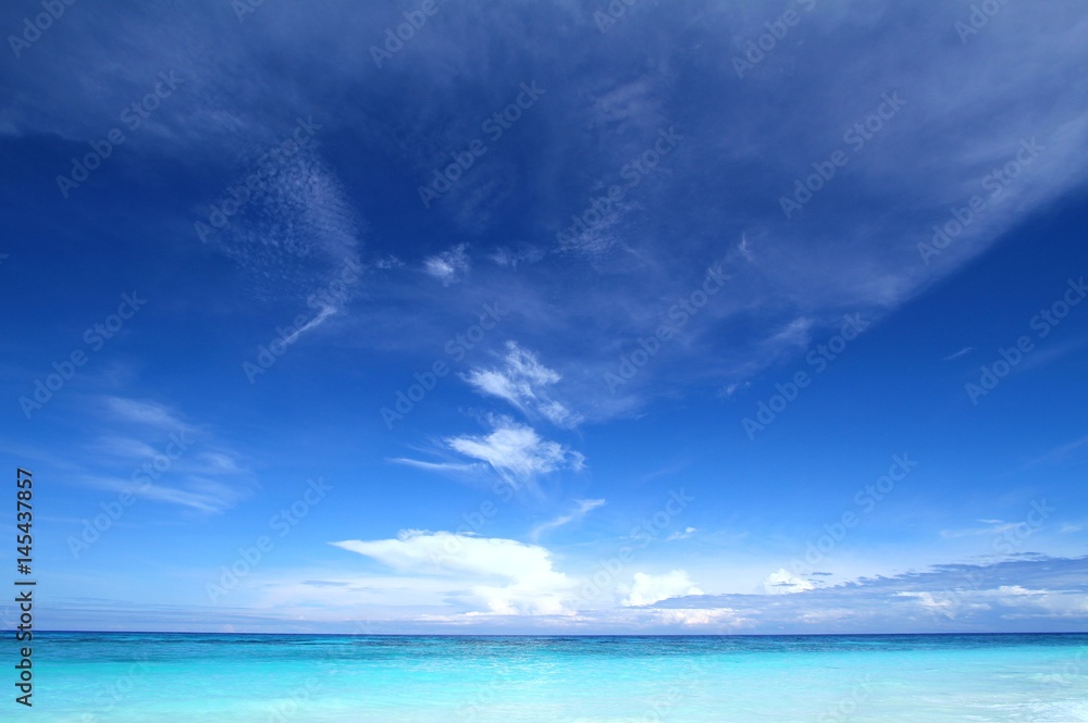 Beautiful tropical seascape with clear blue sky and soft white clouds. Tachai island, Andaman sea, Thailand