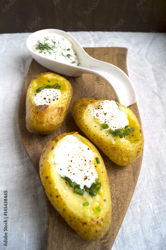 Spicy baked potatoes on wooden Board, closeup Spicy baked potatoes on wooden Board, closeup