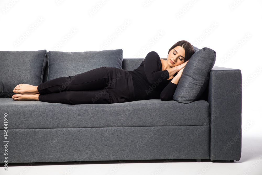 Woman resting her head on a pillow in a couch on white