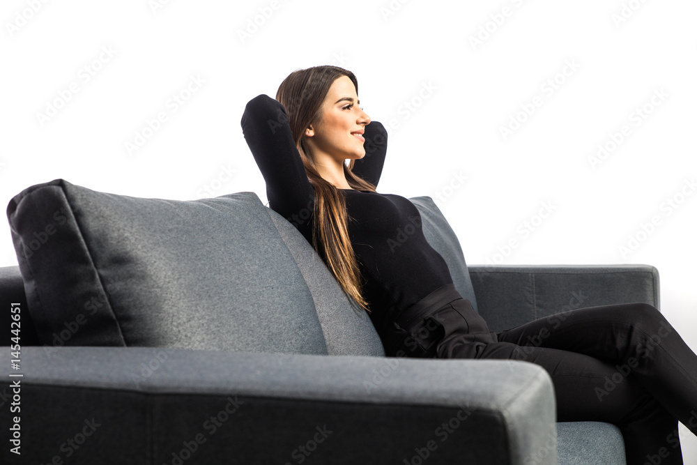 Young woman relaxing on couch with hands bihind head on white background Young woman relaxing on couch with hands bihind head on white background