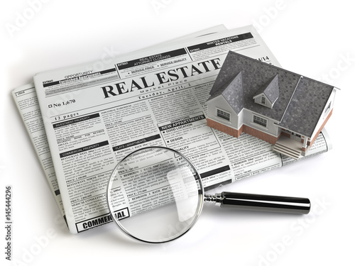 Real estate classifieds ads newspaper with house and magnifying glass isolated on white.