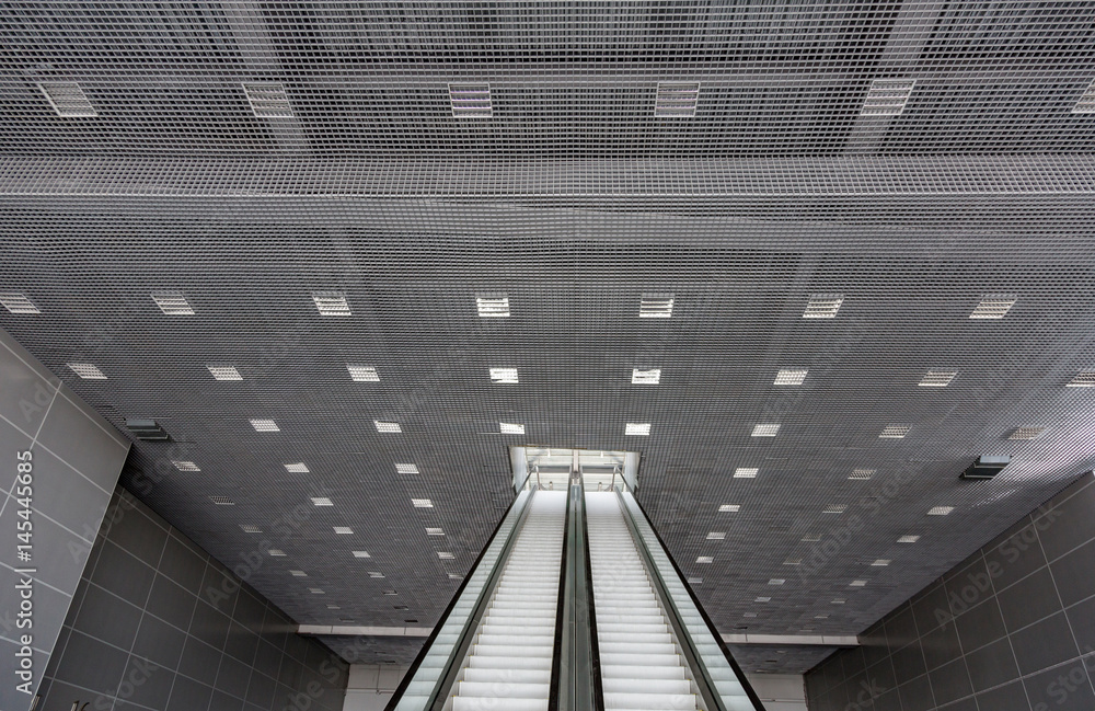 Fototapeta premium Futuristic metal escalator for lifting people in a modern shopping mall 