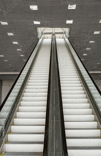 Futuristic metal escalator for lifting people in a modern shopping mall 