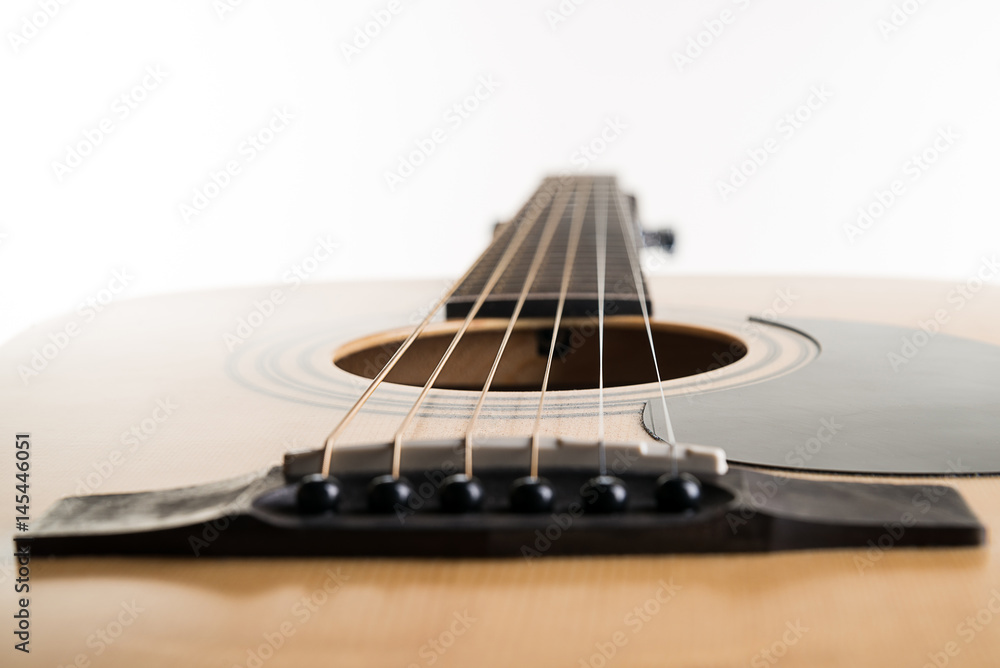 Fototapeta premium Acoustic guitar lies in a frame on a white isolated background. Horizontal frame