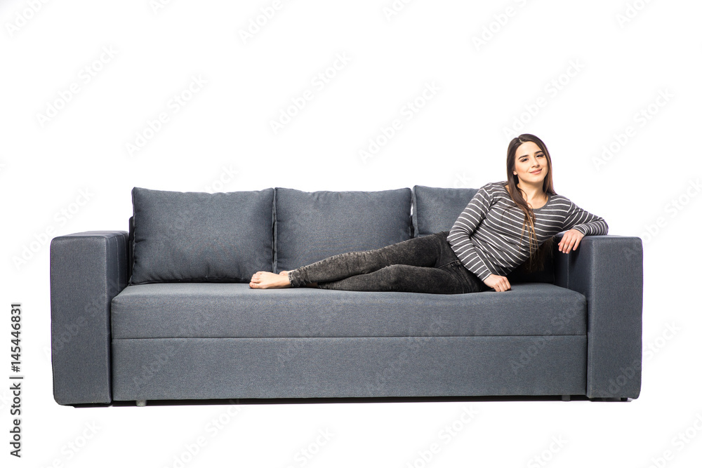 Young female lying on a sofa isolated on white background Young female lying on a sofa isolated on white background