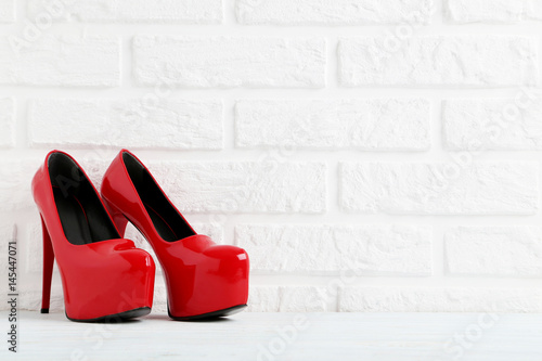 Pair of women's high-heeled shoes on a brick wall background © 5second