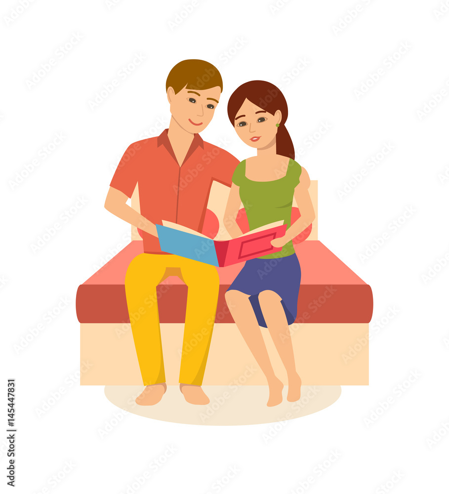 Young family is sitting on bed, viewing photos from album. Young family is sitting on bed, viewing photos from album.