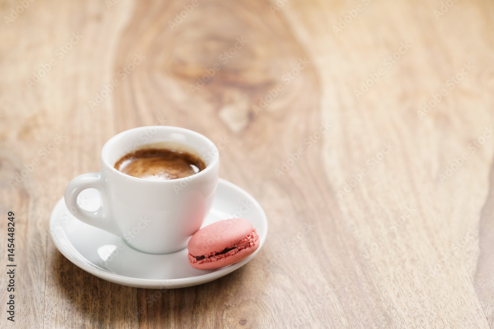 cup of fresh espresso with macarons on wood table with copy space, shallow focus
