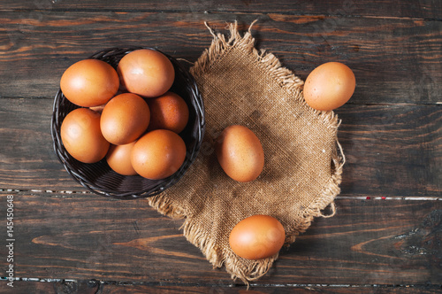 Farm Fresh Brown Chicken Hen Eggs in a Basket on Rustic Wood Counter Background