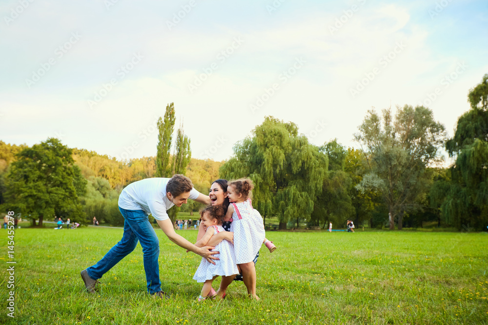 Fototapeta premium Happy family playing with children in the park