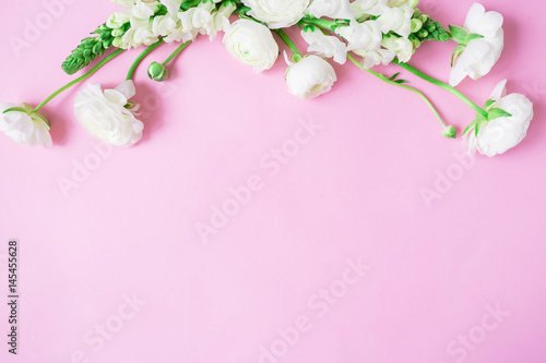 Floral frame of white flowers - ranunculus and snapdragon on pink background. Flat lay, top view. © artifirsov