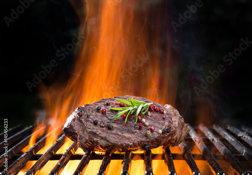Beef steaks on the grill with flames