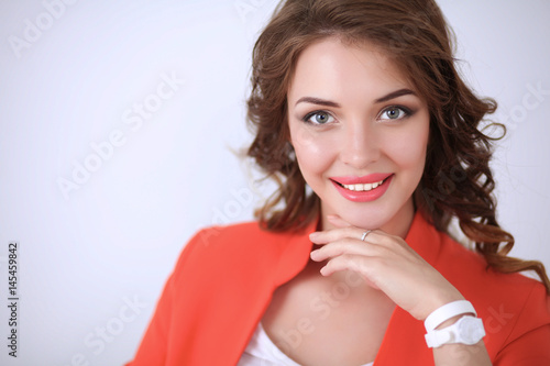 Beautiful woman with curly hair wearing a red jacket  isolated on white background