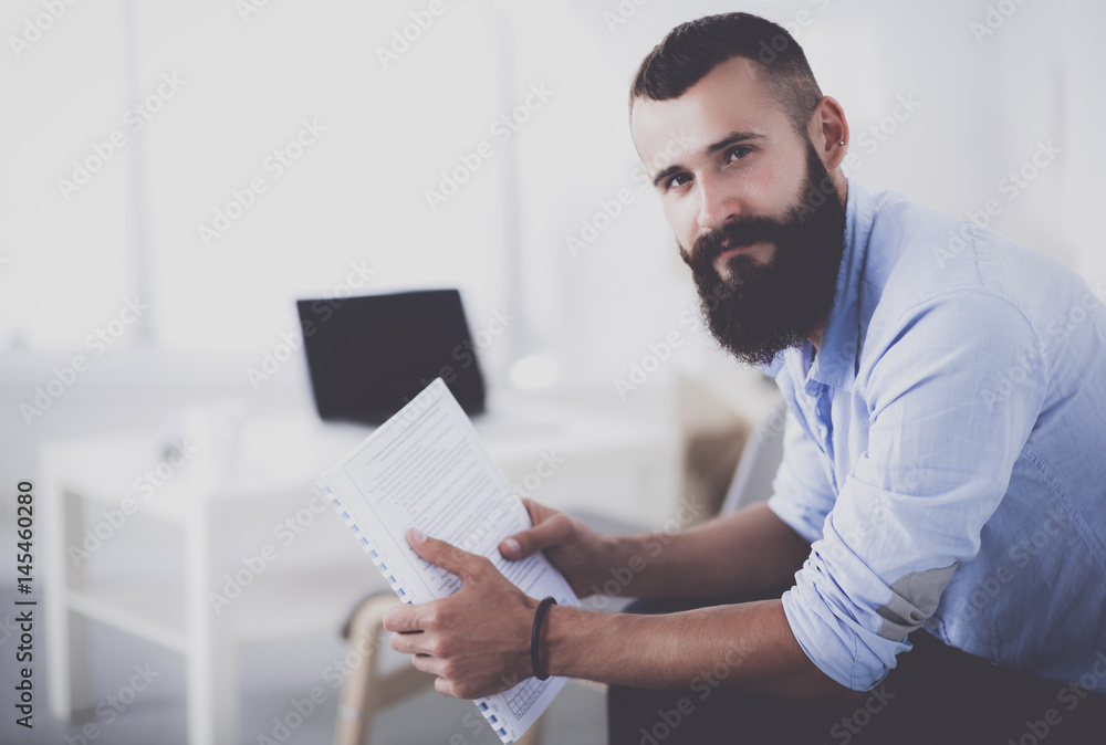 Fototapeta premium Young businessman sitting on chair in office