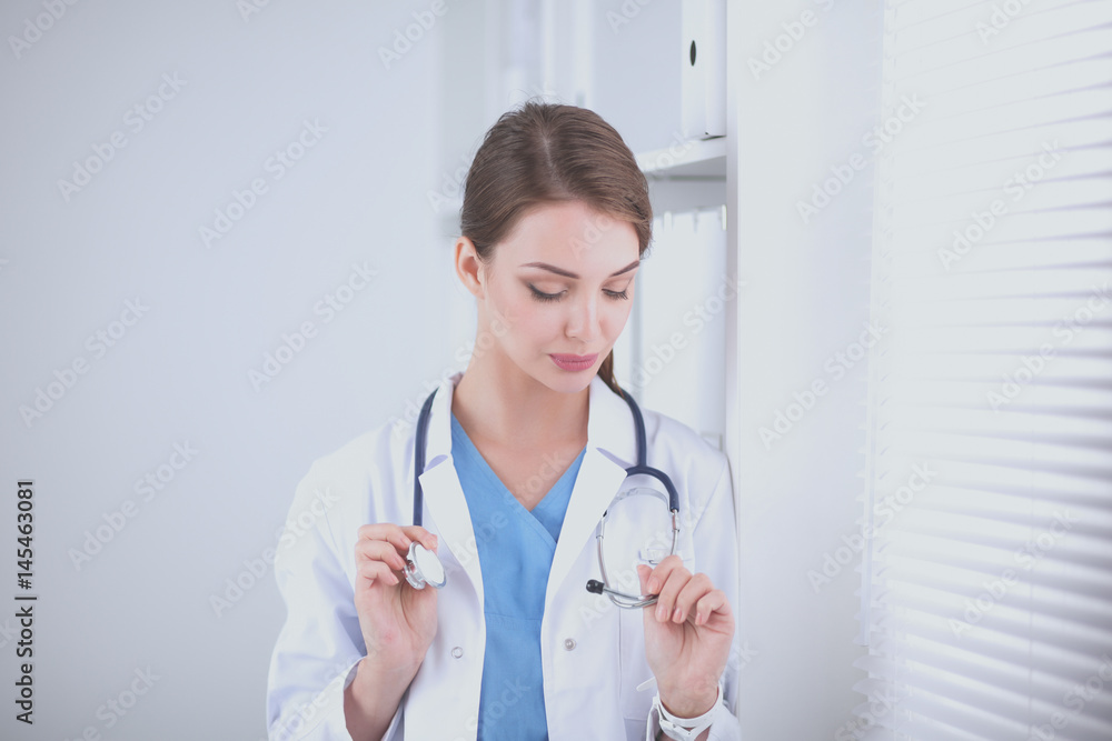 Portrait of young woman doctor with white coat standing in hospital Portrait of young woman doctor with white coat standing in hospital