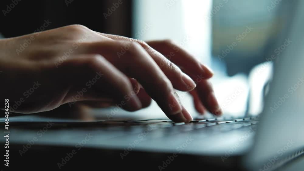 A  business woman's hands working and typing on laptop keyboard 