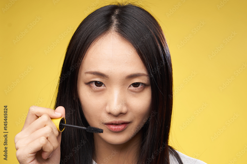 woman paints eyelashes with mascara, makeup woman paints eyelashes with mascara, makeup