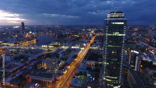 Unique flyover Yekaterinburg City Vysotsky tallest business skyscraper in Russia outside Moscow. Colorful evening night illumination. Eltsyn center at background skyline. Aerial drone flight drift 4k photo